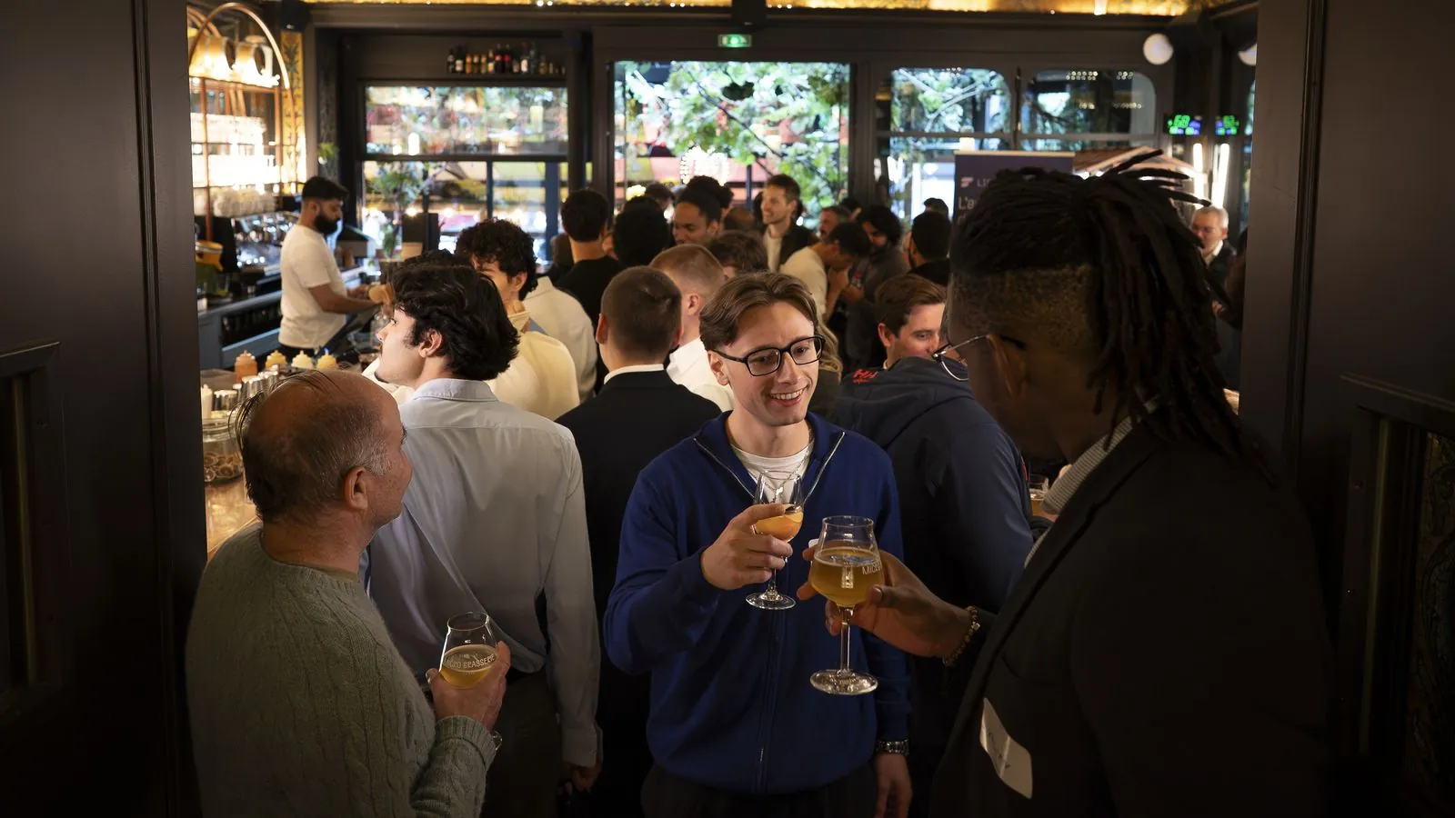 Des membres échangent un verre à la main pendant une soirée à Paris
